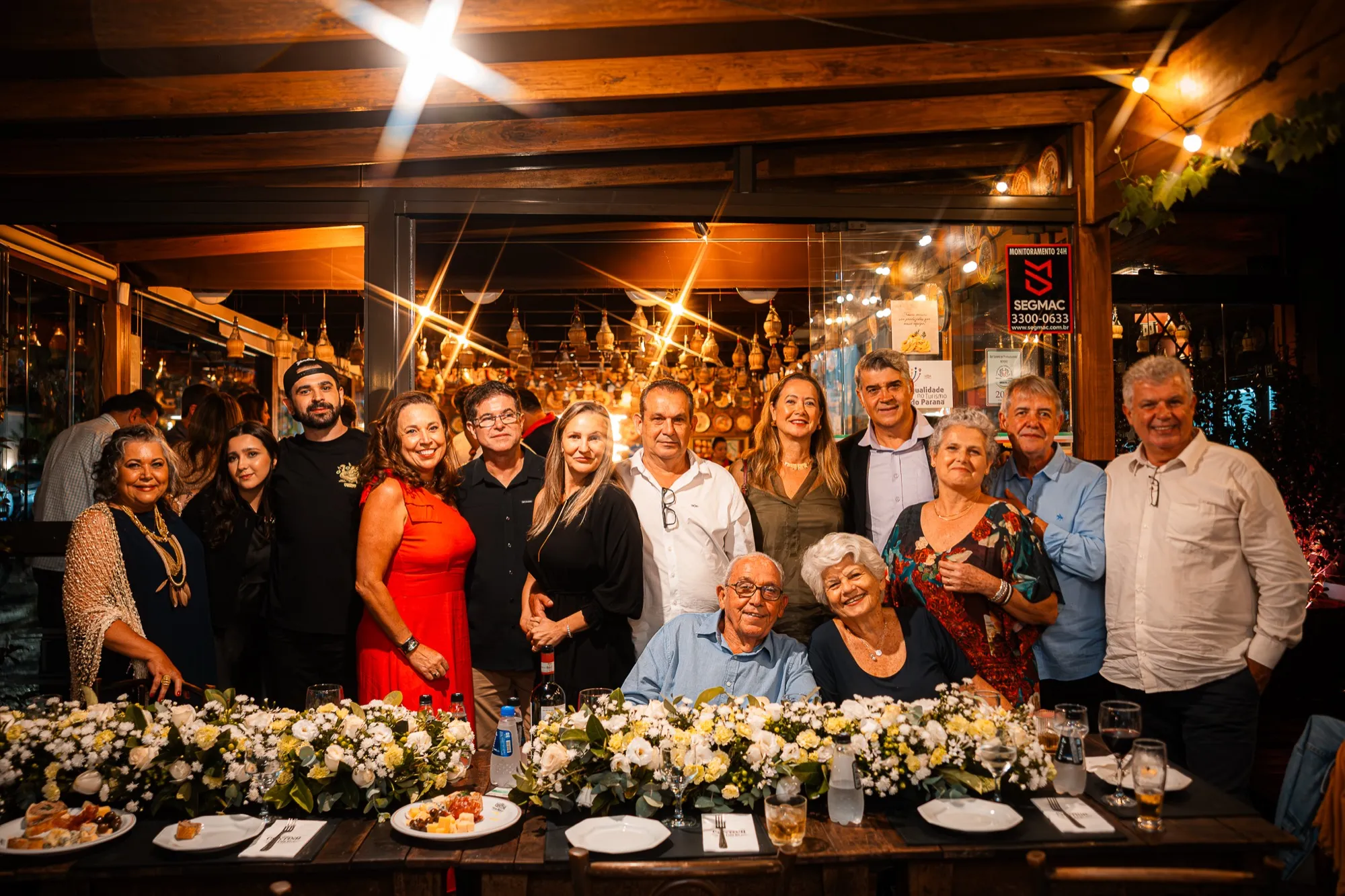 Família reunida em torno da mesa decorada com flores