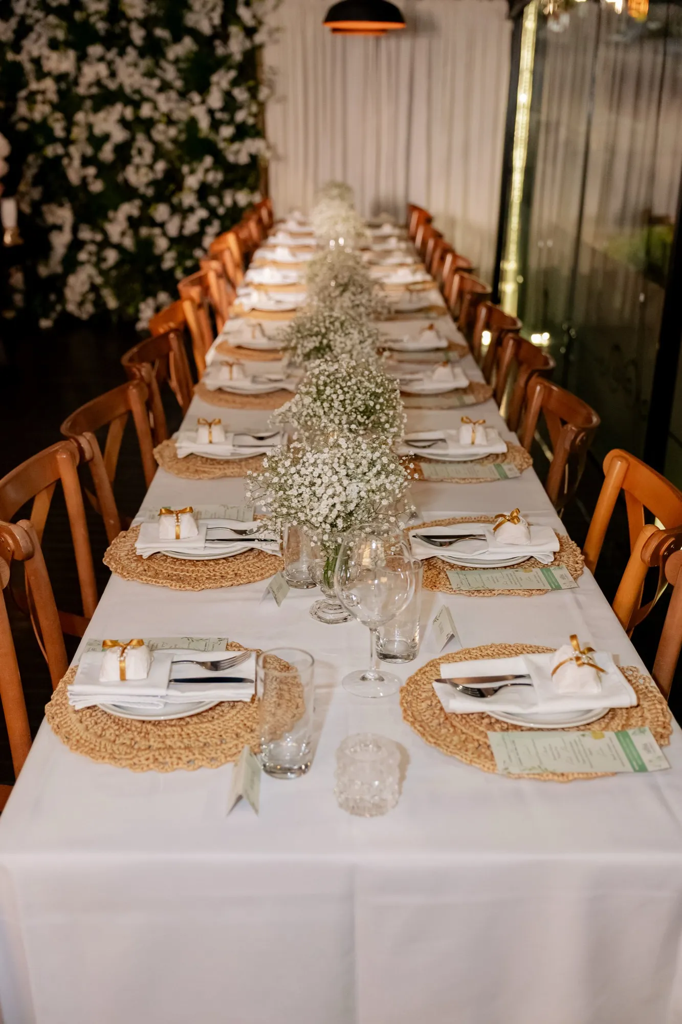 A mesa comprida dos convidados, decorada com flores
