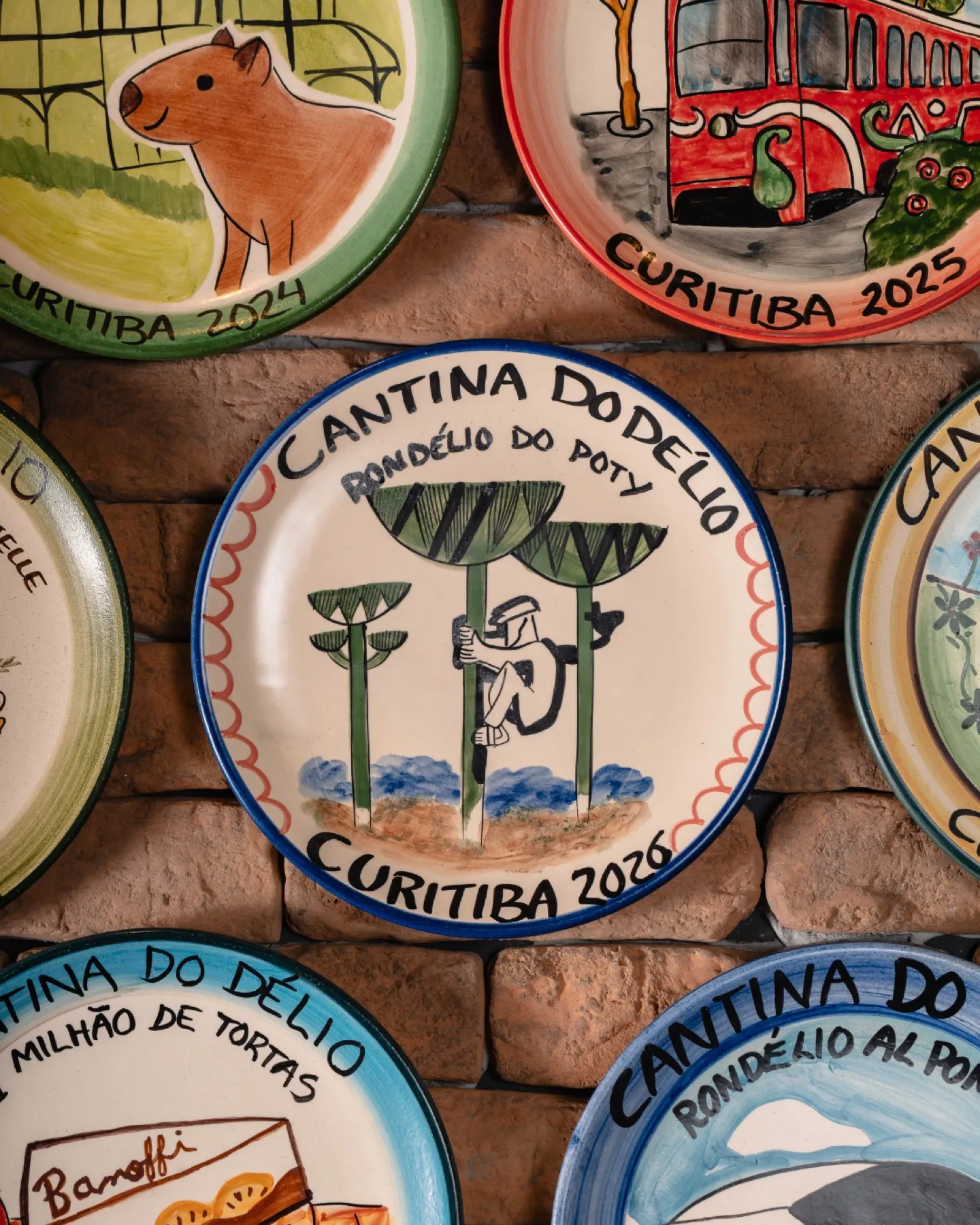 Cerâmicas da Boa Lembrança na parede da Cantina, com o prato do Rondélio do Poty de 2026 no centro